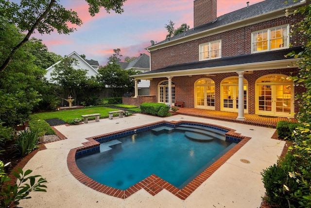 8722 Stable Crest Blvd, Houston, TX 77024 - back of property featuring french doors, brick siding, a chimney, a patio, and an outdoor pool