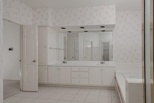 full bath with double vanity, a sink, wallpapered walls, a bath, and tile patterned floors