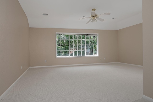 empty room with light colored carpet, visible vents, baseboards, and a ceiling fan