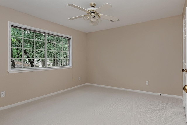 empty room featuring baseboards, light carpet, and ceiling fan