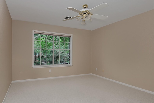 spare room featuring carpet flooring, visible vents, baseboards, and a ceiling fan