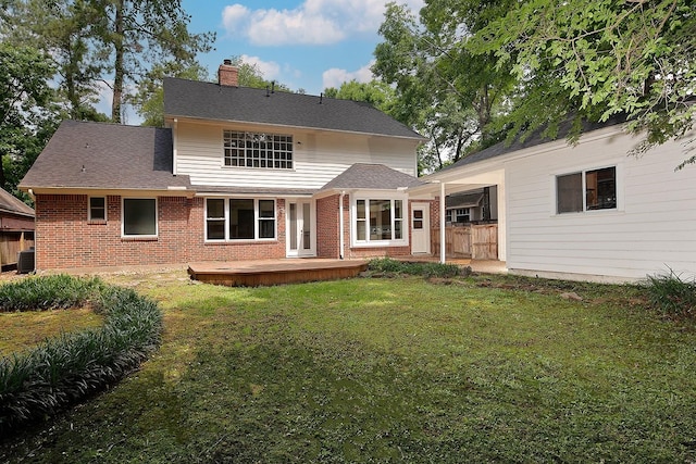 back of property featuring a chimney, a lawn, brick siding, fence, and central AC unit