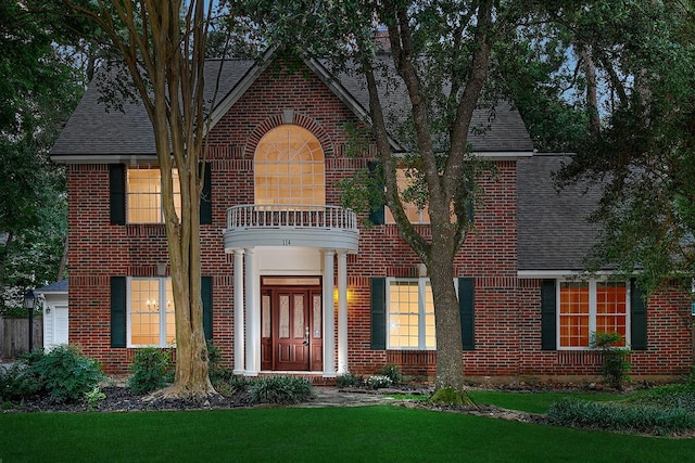 114 S Mill Trace Dr, The Woodlands, TX 77381 - view of front of home with a balcony, brick siding, a shingled roof, and a front lawn