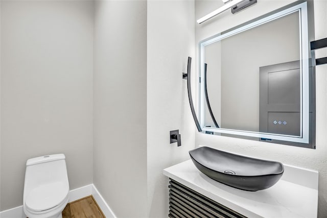 604 W 28th St Unit A, Houston, TX 77008 - half bathroom with baseboards, vanity, toilet, and wood finished floors