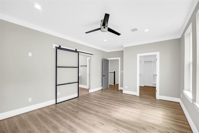 604 W 28th St Unit A, Houston, TX 77008 - unfurnished bedroom featuring light wood finished floors, visible vents, a barn door, and ornamental molding