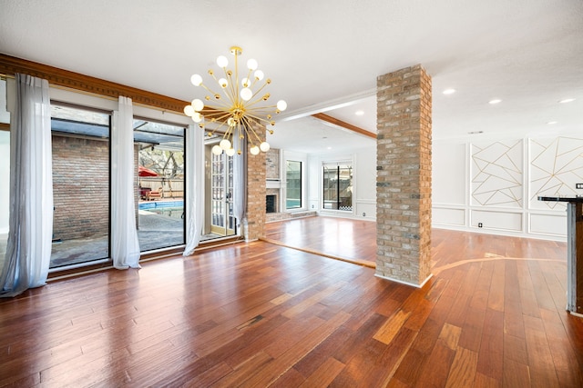 12414 Laneview Dr, Houston, TX 77070 - unfurnished dining area with an inviting chandelier, ornate columns, wood-type flooring, a decorative wall, and recessed lighting