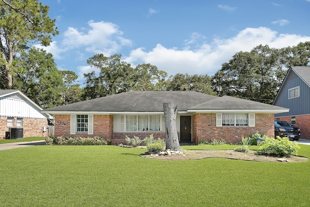view of front facade featuring brick siding, a front yard, and central AC