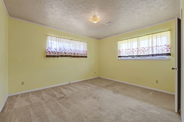 carpeted spare room featuring healthy amount of natural light, a textured ceiling, ornamental molding, and baseboards