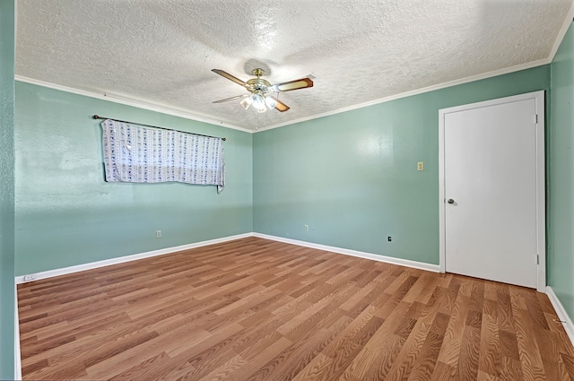 unfurnished room with a textured ceiling, a ceiling fan, wood finished floors, crown molding, and baseboards
