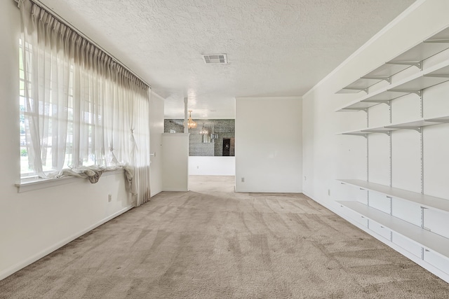 carpeted empty room featuring a textured ceiling and baseboards