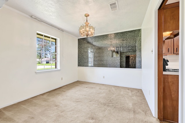 unfurnished dining area featuring a chandelier, carpet flooring, ornamental molding, and a textured ceiling