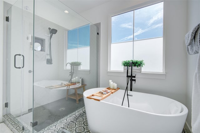 full bath featuring a stall shower and a freestanding bath