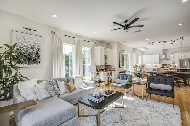 living room featuring light wood-style flooring, ceiling fan, recessed lighting, and beverage cooler