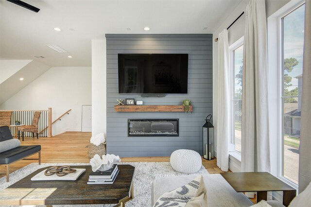 living area featuring wood finished floors, recessed lighting, and a large fireplace
