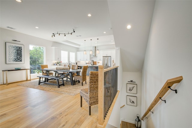 stairs featuring wood finished floors, recessed lighting, a raised ceiling, and baseboards