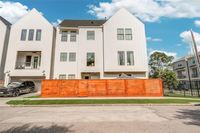 view of front of house with a fenced front yard, an attached garage, and board and batten siding