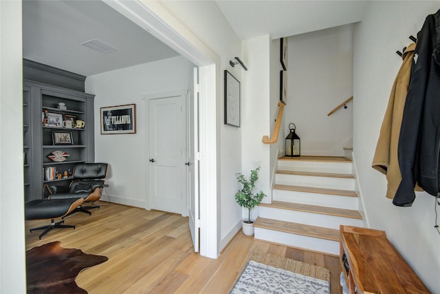 stairway with wood finished floors and baseboards