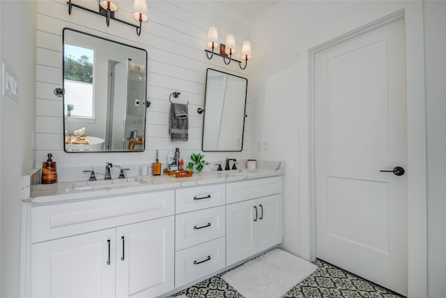 bathroom with tiled shower and double vanity