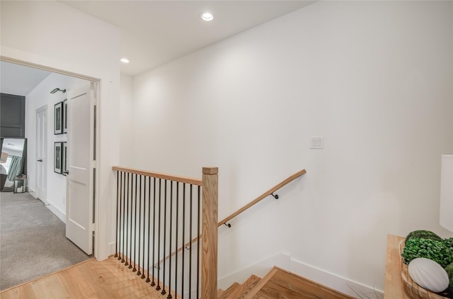staircase featuring wood finished floors, recessed lighting, and baseboards