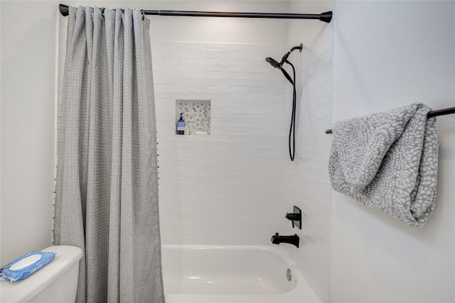 bathroom featuring shower / bath combo and toilet
