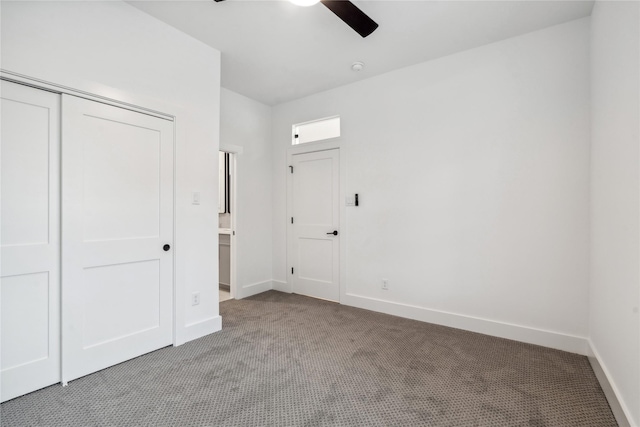 unfurnished bedroom featuring carpet flooring, a closet, baseboards, and a ceiling fan