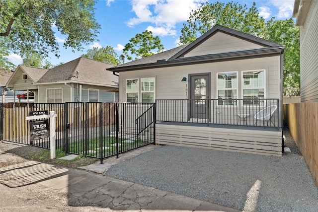 rear view of property with a shingled roof and fence private yard