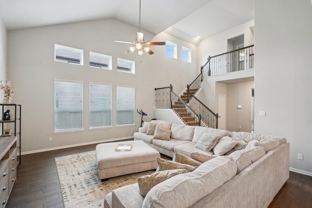 living room with stairs, high vaulted ceiling, dark wood finished floors, ceiling fan, and baseboards