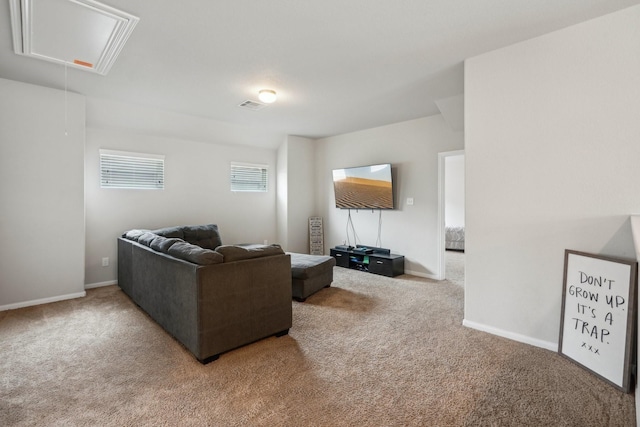 carpeted living area featuring attic access, visible vents, and baseboards