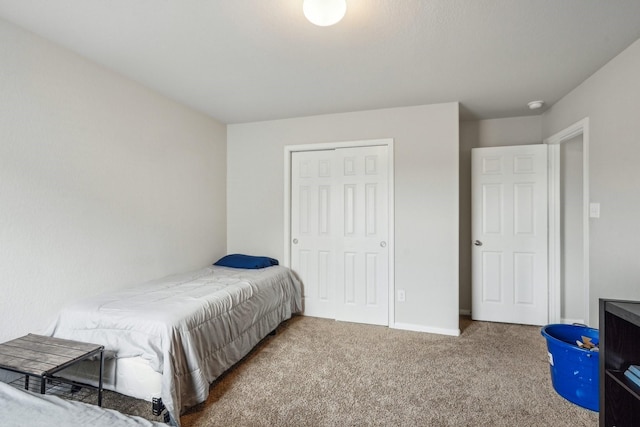 carpeted bedroom featuring a closet and baseboards