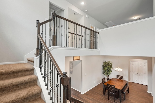 stairway with baseboards, a notable chandelier, recessed lighting, and wood finished floors