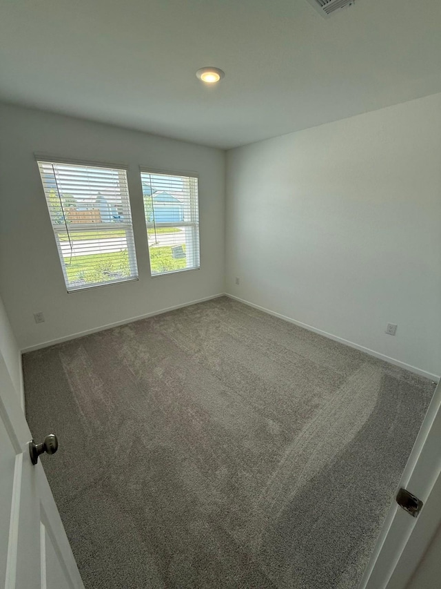 unfurnished room with carpet flooring, baseboards, and visible vents