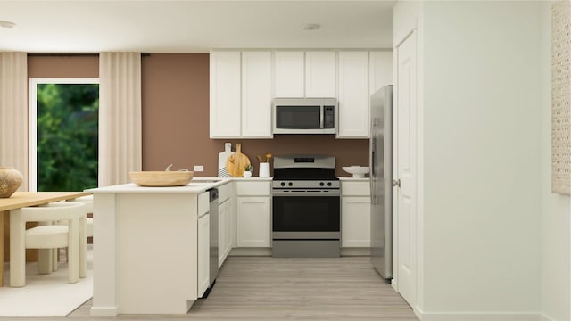 kitchen with a peninsula, light wood-style floors, white cabinetry, light countertops, and appliances with stainless steel finishes