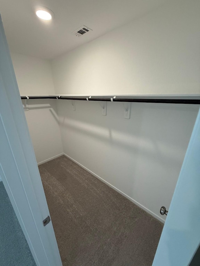 spacious closet with visible vents and dark carpet