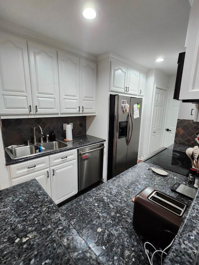kitchen featuring stainless steel appliances, a sink, white cabinets, decorative backsplash, and recessed lighting