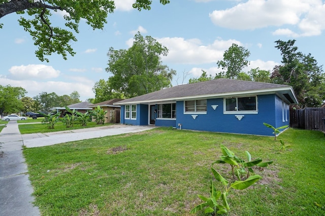 ranch-style house featuring a front lawn, driveway, and fence
