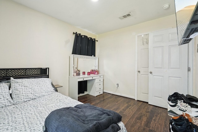 bedroom featuring visible vents, dark wood-style flooring, and baseboards