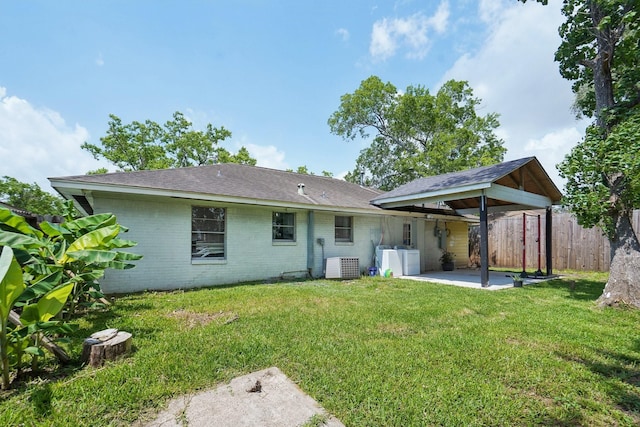 back of property with separate washer and dryer, a yard, fence, a patio area, and brick siding