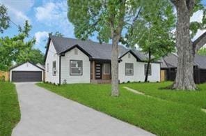 view of front of house featuring an outbuilding, a front yard, and a garage