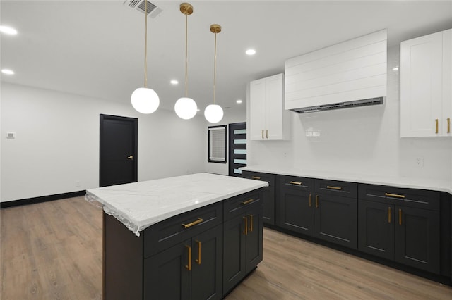 kitchen with white cabinetry, dark cabinetry, light wood-style flooring, a center island, and recessed lighting