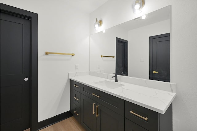 bathroom featuring wood finished floors, vanity, and baseboards
