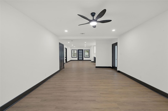 hallway with recessed lighting, light wood-style flooring, and baseboards