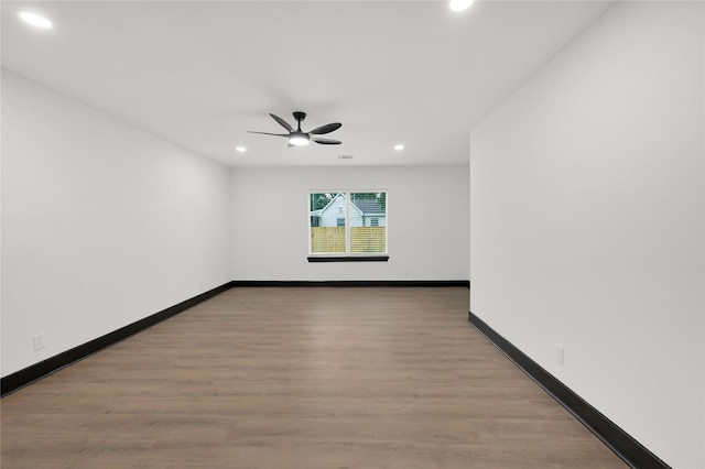 spare room featuring recessed lighting, a ceiling fan, wood finished floors, and baseboards