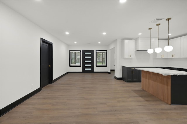 kitchen with white cabinetry, wood finished floors, baseboards, recessed lighting, and hanging light fixtures