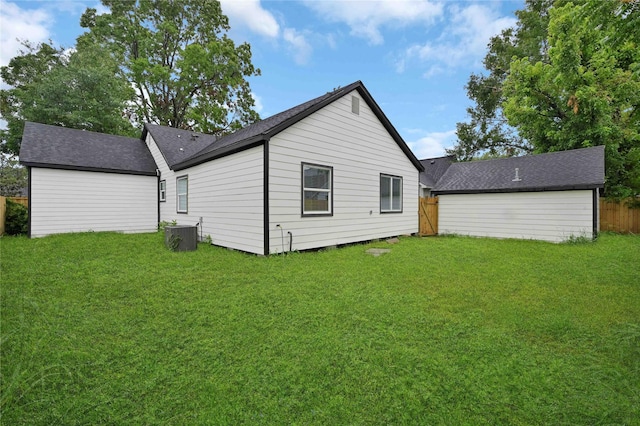 rear view of house featuring roof with shingles and cooling unit