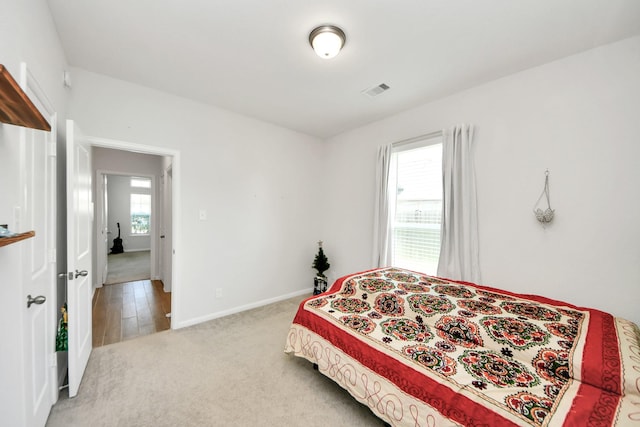 bedroom featuring light colored carpet and baseboards