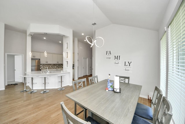 dining area featuring vaulted ceiling, light wood-style flooring, baseboards, and recessed lighting