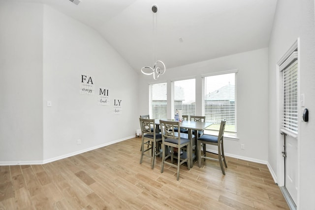 dining space featuring vaulted ceiling, a chandelier, light wood-style flooring, and baseboards