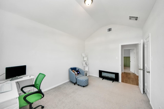 carpeted home office with lofted ceiling and baseboards