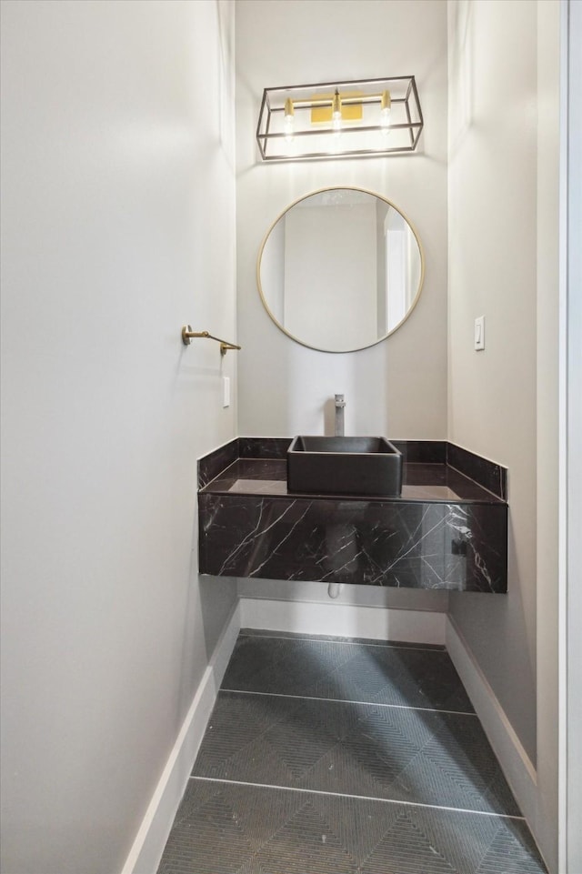bathroom featuring baseboards and a sink