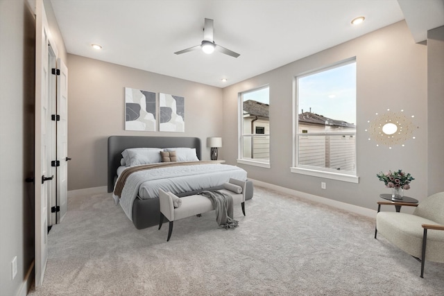 carpeted bedroom featuring baseboards and a ceiling fan